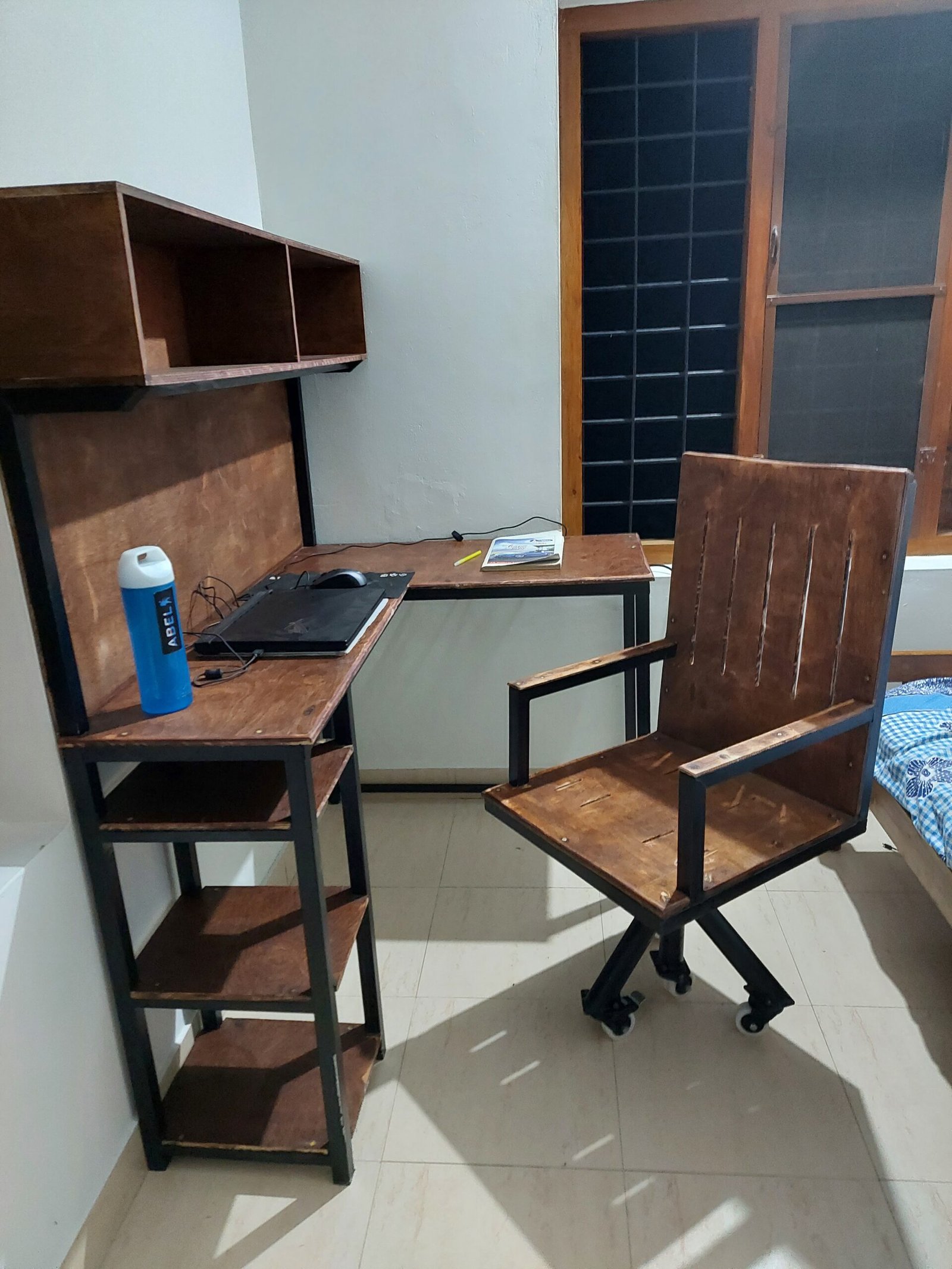 Custom-built wood and metal desk with shelving, paired with a matching rolling desk chair