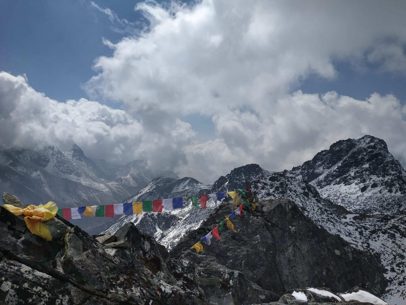 Mountaineer raising a fist in celebration on a snowy slope near the summit